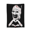 A black and white graphic featuring a menacing, stylized skull face with blood splatter details.