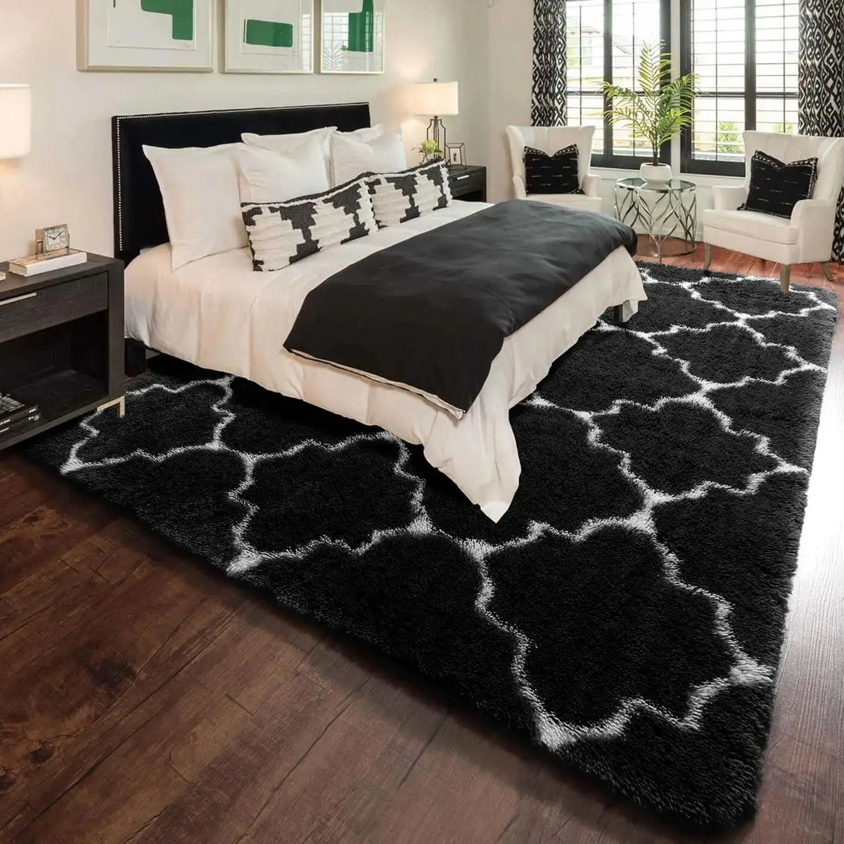 A black and white geometric plush area rug placed in a modern bedroom setting.