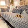 A plush, ribbed gray sofa seat cushion cover with white accent pillows and gold decorative accents.