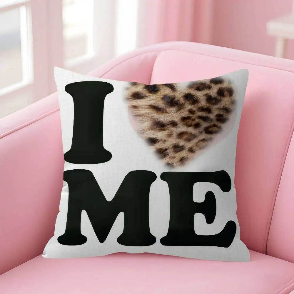 A white decorative pillow cover with the text I ME in black letters and a leopard print heart design
