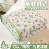 White quilted blanket with floral pattern folded neatly on a white surface