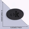 A black embroidered leather patch with the letter OK on it, shown against a white background.