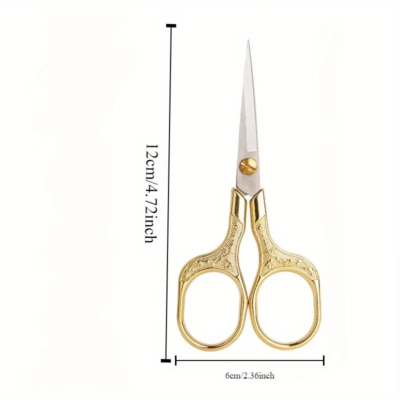 A pair of vintage stainless steel sewing scissors with gold-colored handles and a sharp blade.