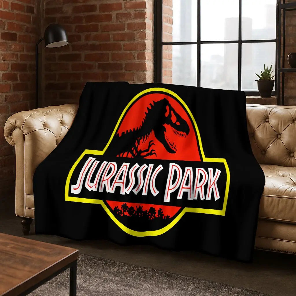 A black flannel throw blanket featuring a red dinosaur silhouette and the text Jurassic Park in yellow and white.
