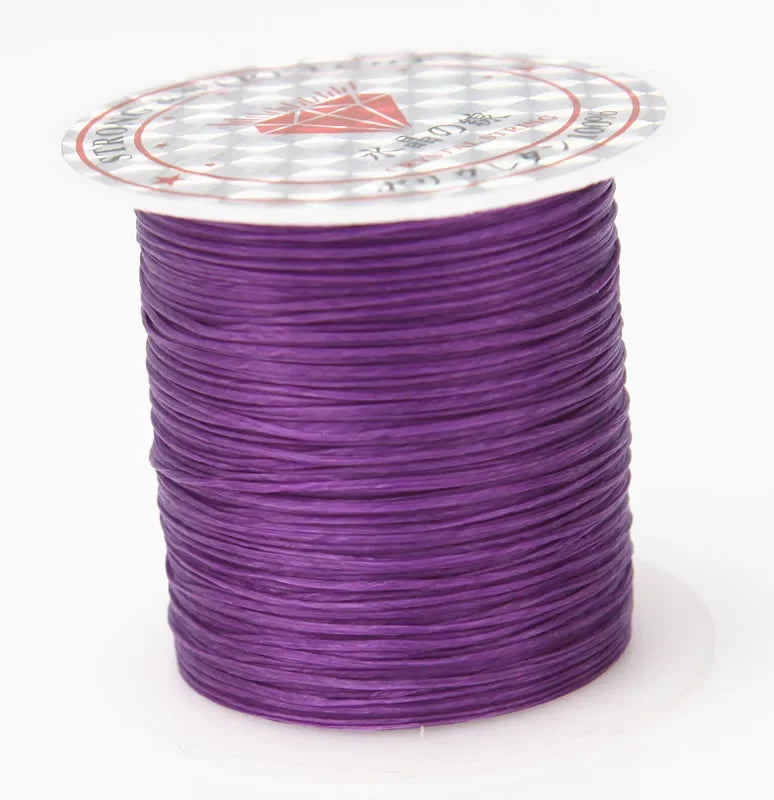 A spool of purple multicolor elastic beading cord with a decorative label on top.