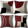 A set of four abstract geometric throw pillow covers in shades of maroon, black, gray, and beige.