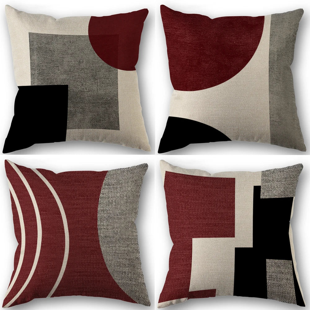 A set of four abstract geometric throw pillow covers in shades of maroon, black, gray, and beige.