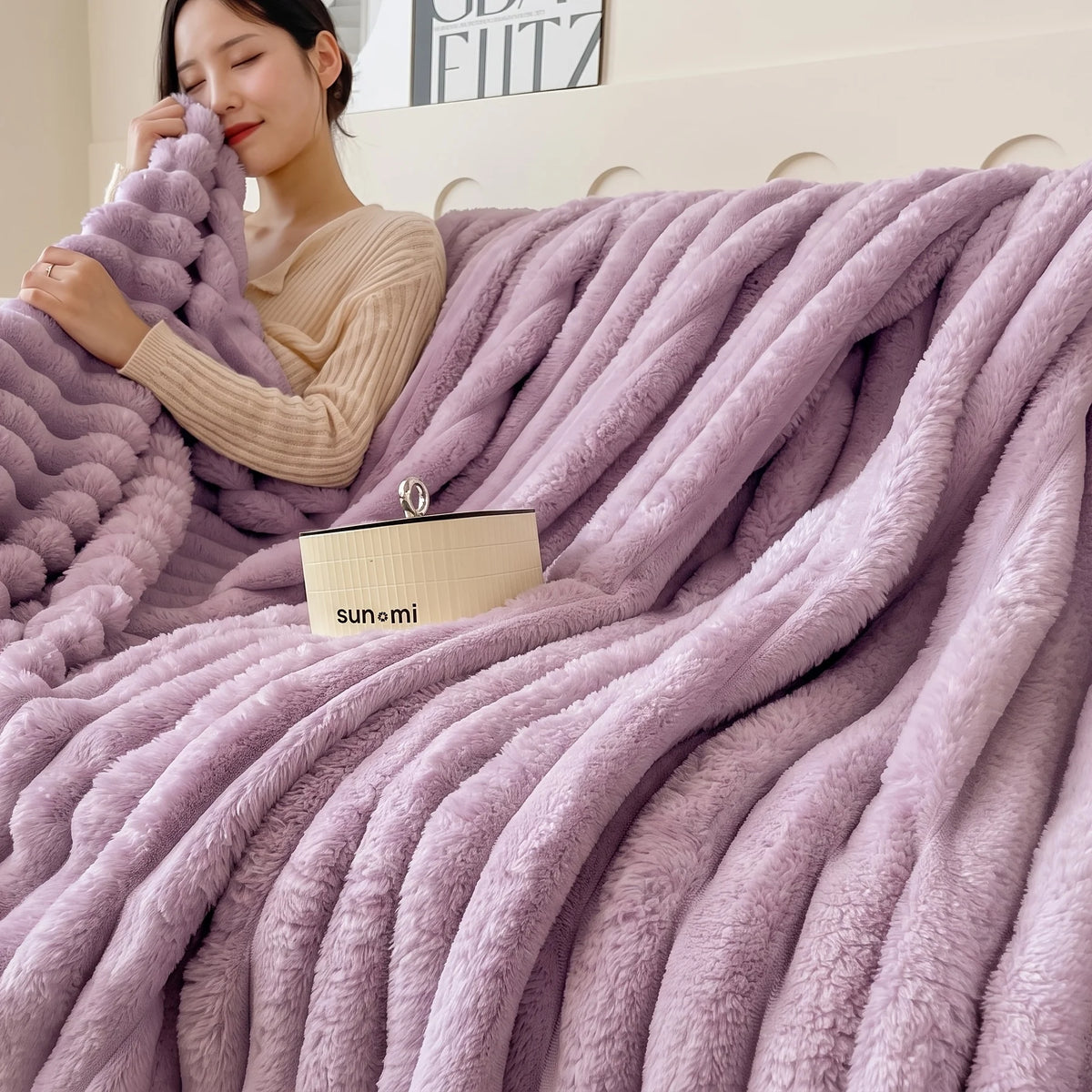 A woman is wrapped in a thick, fluffy lavender fleece throw blanket indoors.