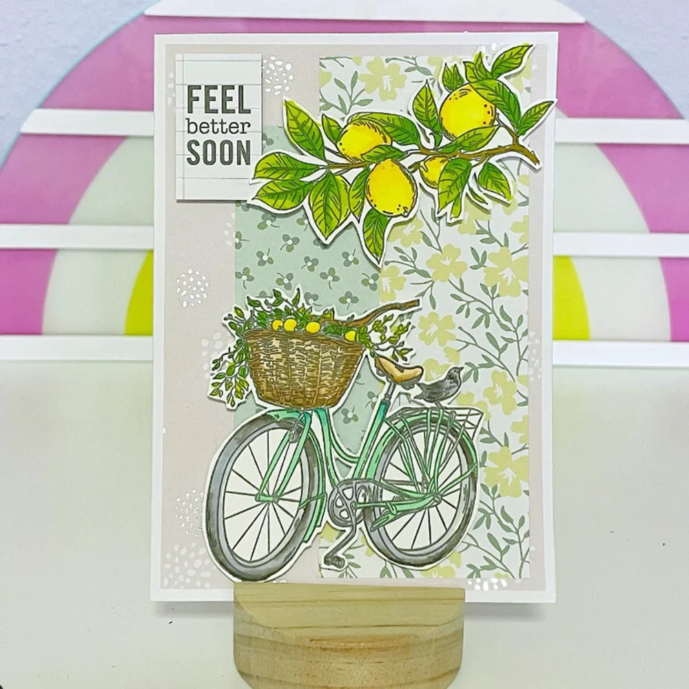 A card featuring a watercolor illustration of a bicycle with fruit and flowers, designed for scrapbooking.