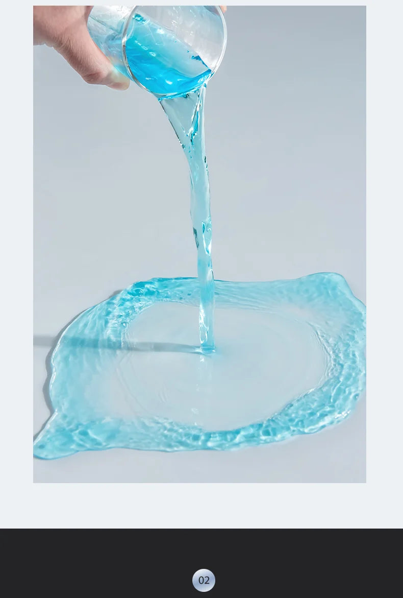 A hand pours clear blue liquid into a glass, creating ripples on the surface.
