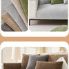 A close-up of various textured throw pillows in shades of green, beige, and gray displayed on a sofa.
