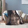A muscular male figure is displayed on a cozy throw blanket in a modern living room setting.