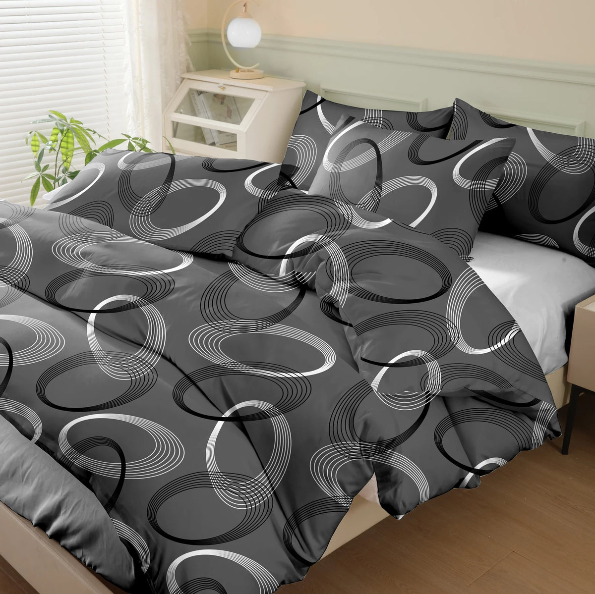 A dark gray printed quilt set featuring concentric white and gray circular patterns on a bed.