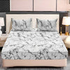 A fitted sheet set featuring a white and black marble print on a bed with matching pillows.