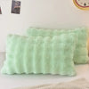 A light mint green faux fur decorative pillow cover resting on a white surface.