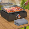A silicone griddle mat cover is being used to cook meat on an outdoor grill.