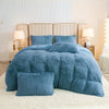 A fluffy blue plush duvet cover set displayed on a bed with light wood accents and white bedding.