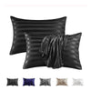 A set of black and silver striped pillow covers, including standard pillows and a draped fabric piece.