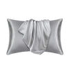 A silver satin silk pillow cover is shown folded, ready for use.