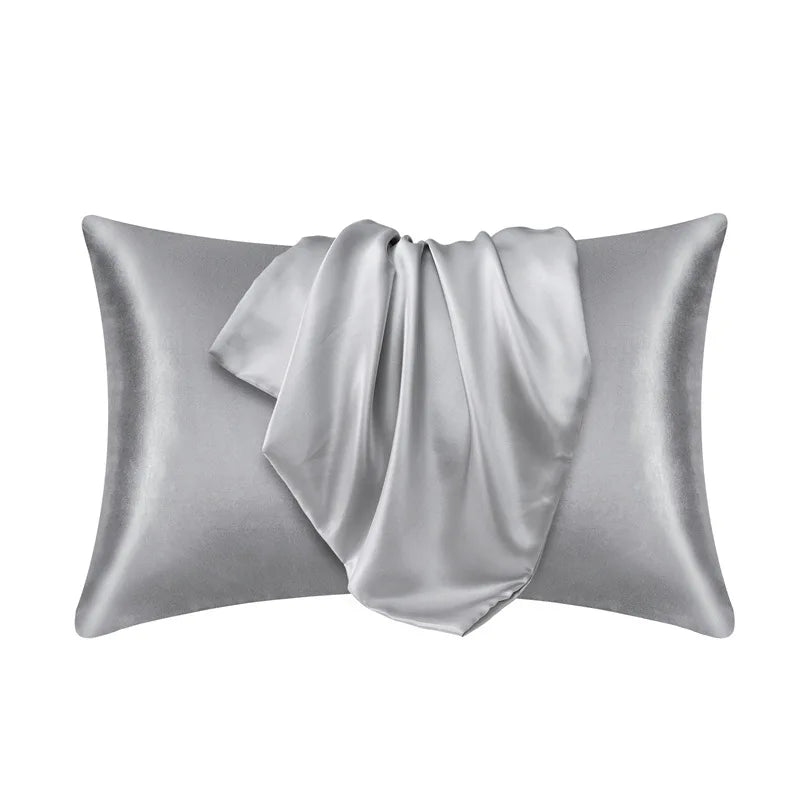 A silver satin silk pillow cover is shown folded, ready for use.