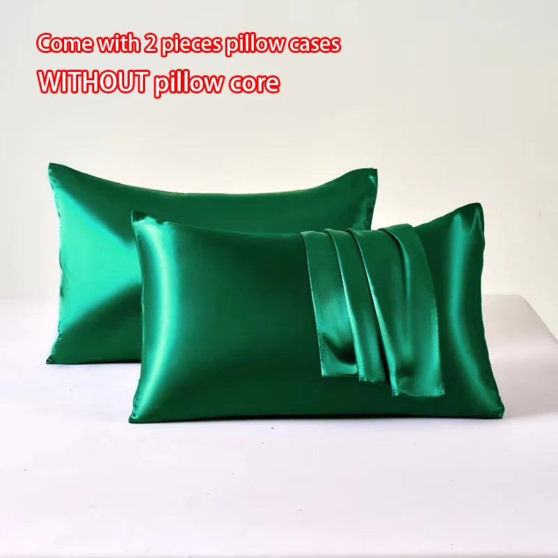 Two emerald green satin pillow cases without a pillow core