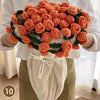 A hand knitted floral rose bouquet arrangement wrapped in a cream colored throw blanket.