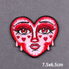 A red heart embroidered patch featuring a stylized female face with dramatic eye makeup and small red hearts.