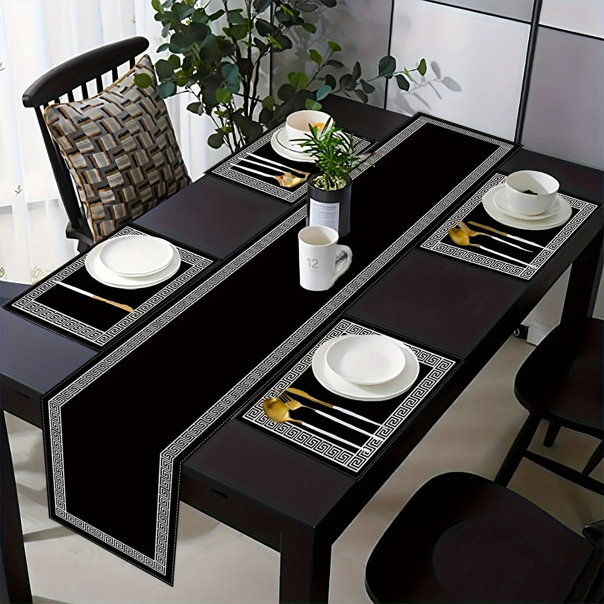 A set of luxury geometric placemats and table runners featuring black and white patterns on a dark wooden table.