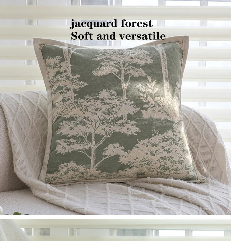 A square cushion cover featuring a jacquard forest pattern in muted green and cream tones.