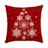 A deep red pillow featuring a white snowflake pattern.