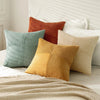 A set of four neutral corduroy throw pillow covers in shades of orange, green, and beige with a patchwork design.