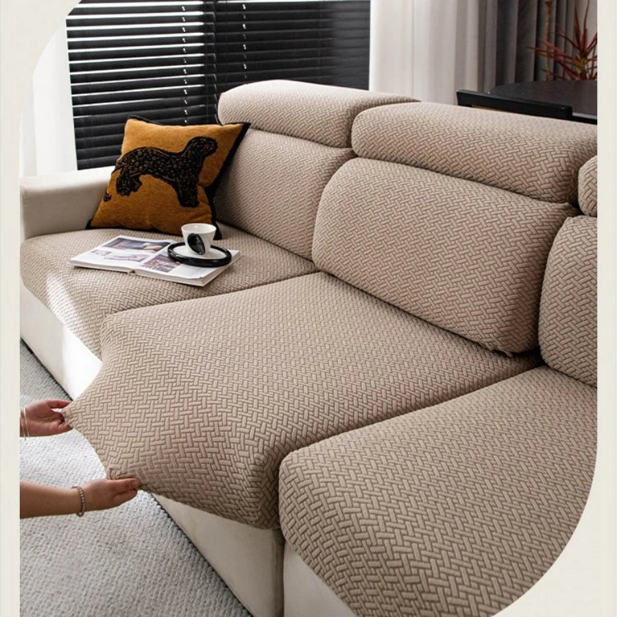 A beige stretchy polar fleece sofa cover is shown on a light-colored sofa with a dark window blind.