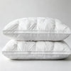 A pair of white hotel-grade memory foam sleeping pillows stacked on a light gray surface.