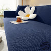 A deep blue textured sofa cover features a modern design with white, petal-like accent pillows.