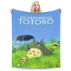A fabric blanket featuring the Totoro character in a grassy outdoor setting.