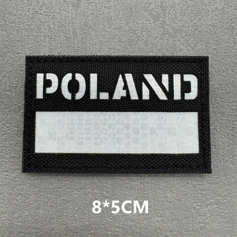 A black rectangular patch with the word POLAND in white text on a gray background.