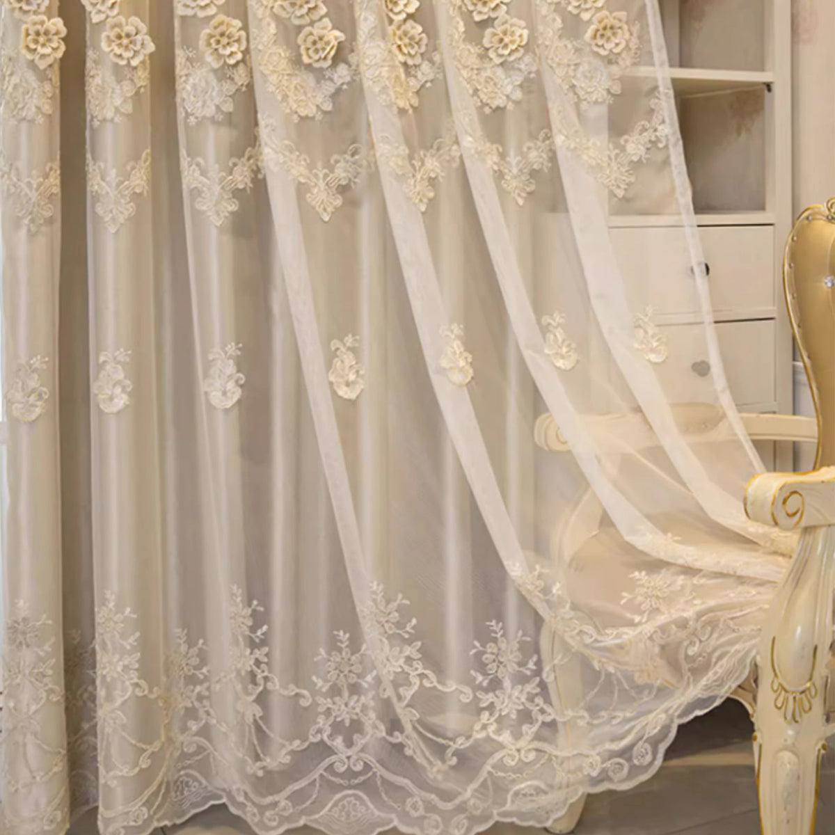 Elegant cream lace curtain with eyelet top draped over a white wooden furniture piece.