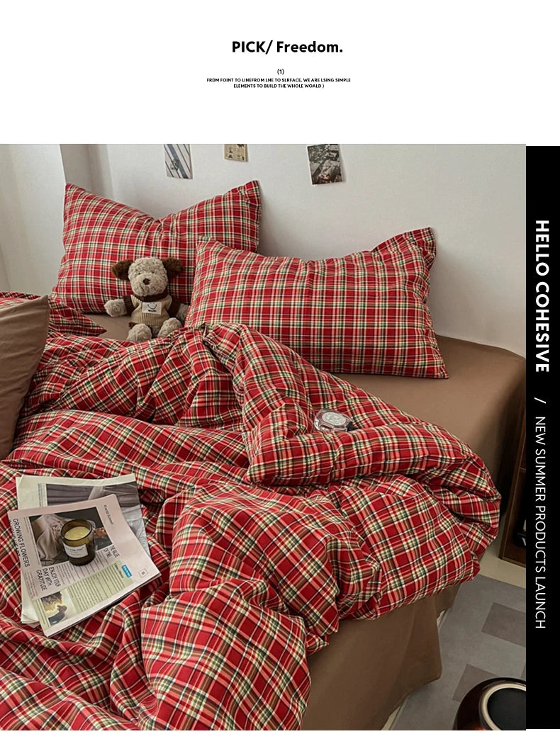 A red and green plaid duvet cover set is displayed on a bed, with pillows and a folded blanket visible.