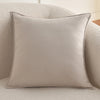 A light beige luxury chenille throw pillow cover resting on a soft, textured sofa.