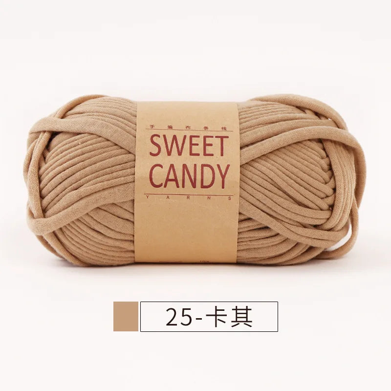 A ball of beige hand-dyed fabric strip yarn labeled Sweet Candy yarns.