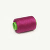 A roll of magenta sewing thread with a green core.