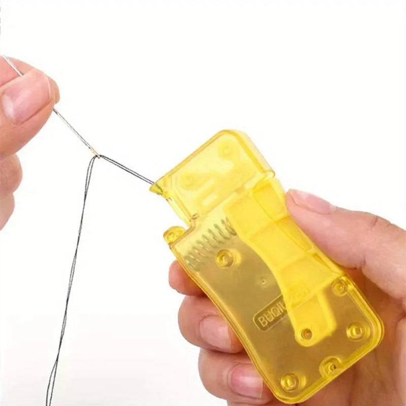 A hand is using a manual automatic needle threader for crafting to thread a needle.