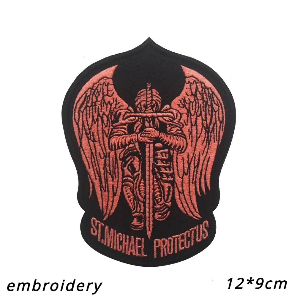 Black embroidered patch featuring a stylized angel with outstretched wings and the text St Michael Protectus.