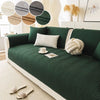 A deep emerald green anti-slip fabric sofa cushion cover with a quilted pattern and decorative pillows.
