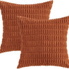 Two rust-colored corduroy throw pillow covers with vertical ribbed texture.