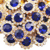 Close-up of gold and blue crystal rhinestone buttons arranged in a floral pattern.