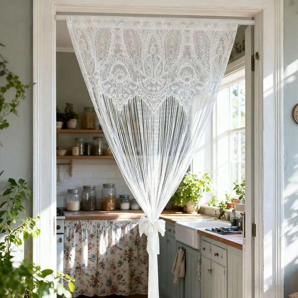 White vintage lace tassel door curtains hanging in a light-colored door frame.