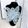 A light blue floral lace applique fabric patch decorated with sparkling sequins displayed on a black mannequin.