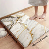 A rectangular marble pattern door mat with gold veining placed on a wooden floor.