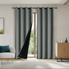 Gray blackout privacy curtains hanging on a rod in a bright room.